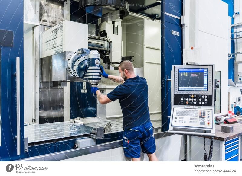 Mann arbeitet an einer Maschine in einer Industriefabrik Maschinen Fabrik Fabriken Männer männlich arbeiten Arbeit Gerät Geräte Erwachsener erwachsen Mensch