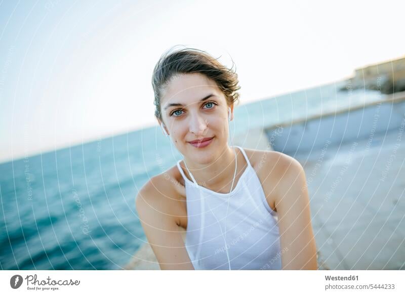 Porträt einer jungen Frau an der Küste Meer Meere sitzen sitzend sitzt weiblich Frauen Gewässer Wasser Erwachsener erwachsen Mensch Menschen Leute People