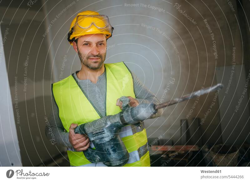 Porträt eines Bauarbeiters, der einen Presslufthammer hält Baustelle Baustellen arbeiten Arbeit Handwerker Handwerksberuf Handwerksberufe Gewerbe Konstruktion
