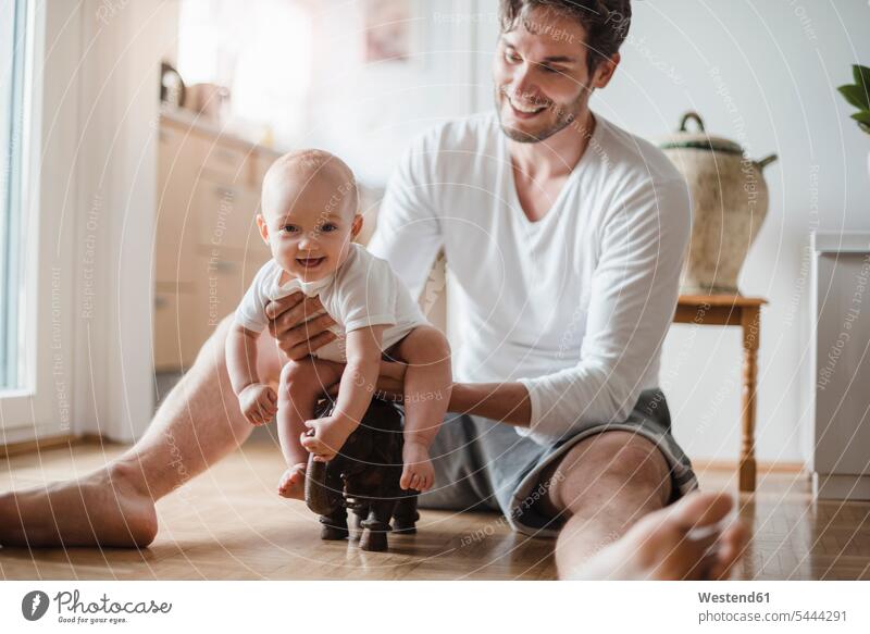 Glücklicher Vater mit Mädchen spielt zu Hause Baby Babies Babys Säuglinge Kind Kinder Papas Väter Vati Vatis Papis lächeln Mensch Menschen Leute People Personen