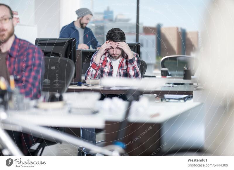 Mann konzentriert sich am Schreibtisch im Büro denken nachsinnen Office Büros Konzentration konzentrieren Männer männlich Arbeitsplatz Arbeitsstätte