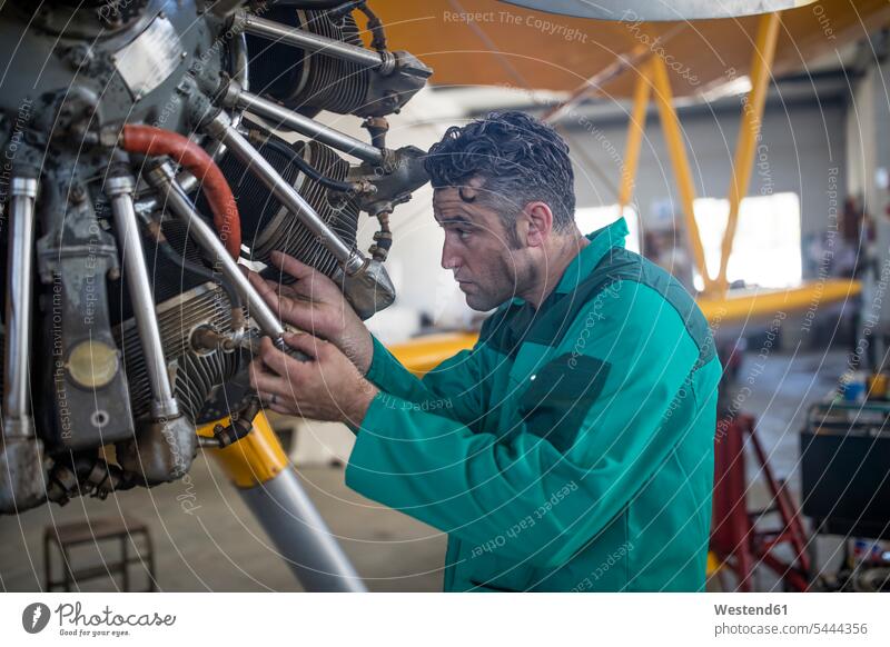 Mechaniker im Hangar bei der Reparatur von Leichtflugzeugen Monteur Flugzeug Flieger Flugzeuge reparieren arbeiten Arbeit Industrie industriell Gewerbe