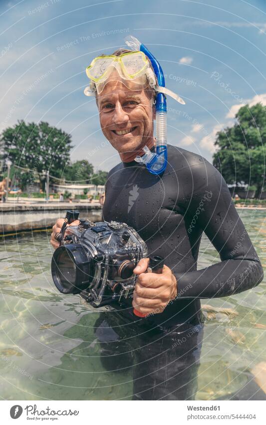 Porträt eines glücklichen Mannes mit Unterwasser-DSLR-Kamerakoffer in einem See Kameras tauchen Männer männlich lächeln Fotoapparat Fotokamera Taucher