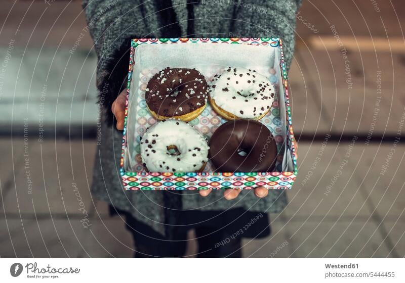 Frauenhaltebox mit Doughnuts, Teilansicht Donut Donuts Karton Pappkartons Kartons Gebäck Backware Gebaeck Backwaren Süßspeise Süsses Süßes süß Süßspeisen Essen