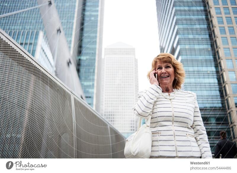 Großbritannien, London, lächelnde ältere Geschäftsfrau am Telefon in der Stadt Geschäftsfrauen Businesswomen Businessfrauen Businesswoman Portrait Porträts