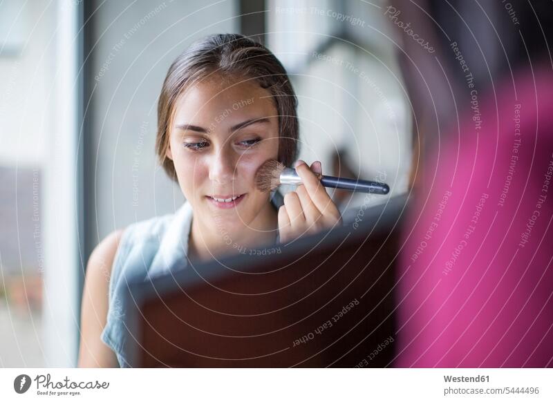 Mädchen schminkt sich, während die Mutter den Spiegel hält Beauty Schoenheit Schönheit schminken Make up Make-up Schminke anwenden auftragen Europäer Kaukasier