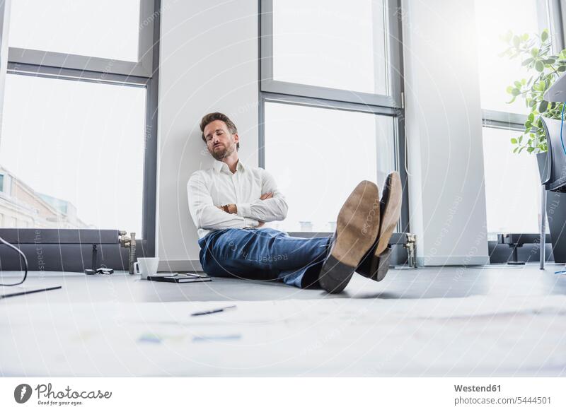 Geschäftsmann entspannt sich auf dem Boden seines Büros Office Fußboden Fußboeden Fussboeden Fussboden Fußböden Fussböden Arbeitsplatz Arbeitsstätte