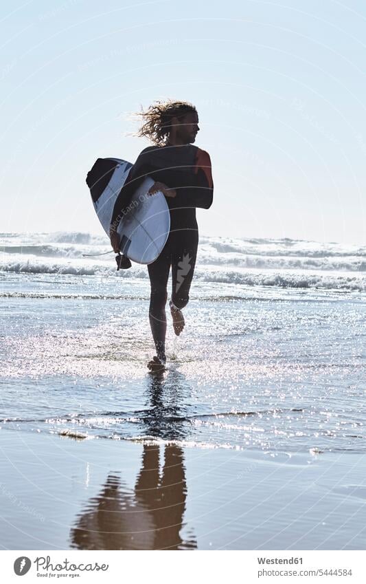 Portugal, Algarve, Mann läuft mit Surfbrett im Wasser Strand Beach Straende Strände Beaches Surfbretter surfboard surfboards rennen Surfen Surfing Wellenreiten