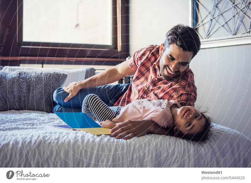 Vater und Tochter spielen im Bett Papas Väter Vati Vatis Papis knuddeln umarmen Betten Gemeinsam Zusammen Miteinander Töchter Eltern Familie Familien Mensch
