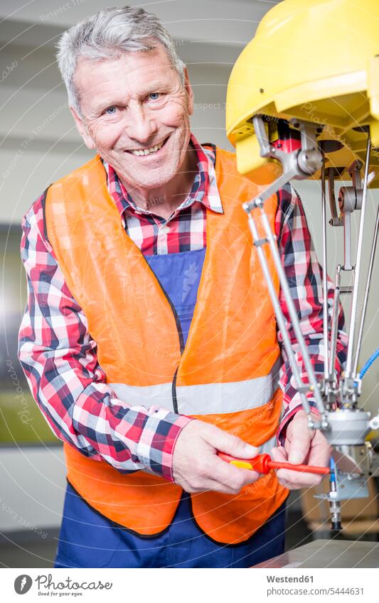 Porträt eines lächelnden Technikers, der einen Industrieroboter einstellt arbeiten Arbeit Fabrik Fabriken industriell Gewerbe Industrien Unternehmen Firma