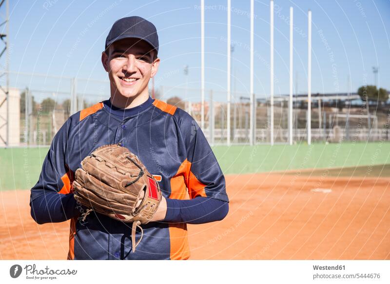 Porträt eines lächelnden Baseballspielers mit einem Baseballhandschuh Baseballer Portrait Porträts Portraits Sport Sportplatz Sportplaetze Sportplätze Handschuh