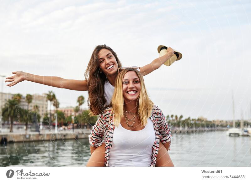 Spanien, Barcelona, junge Frau, die ihren Freund Huckepack nimmt Spaß Spass Späße spassig Spässe spaßig Freundinnen glücklich Glück glücklich sein glücklichsein