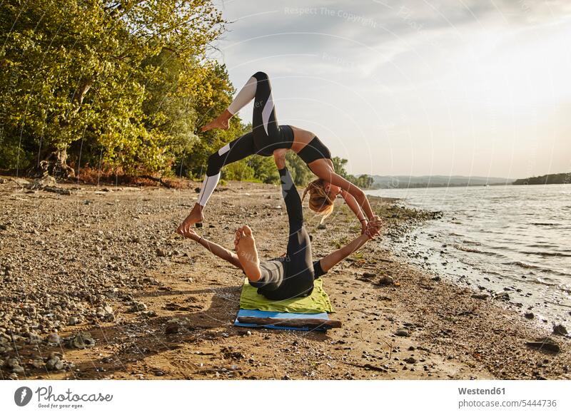 Akro-Yoga praktizierender junger Mann und Frau Rückwärtsbeuge Trainieren Übung Üben Übungen Acro Yoga Akrobatik balancieren Balance Fluss Fluesse Fluß Flüsse