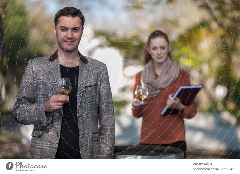 Mann und Frau mit Weingläsern im Freien Weinprobe Weinproben Marketing Weinglas Fachverkäufer Verkäufer Weingut Weingüter Weingueter verkaufen Weine Verkäuferin