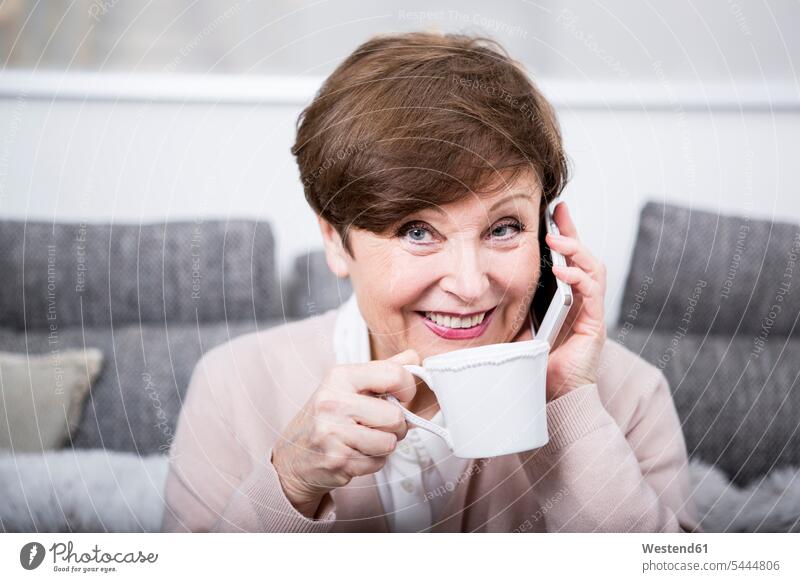 Porträt einer älteren Frau, die ein Smartphone benutzt und Kaffee trinkt weiblich Frauen trinken Handy Mobiltelefon Handies Handys Mobiltelefone iPhone