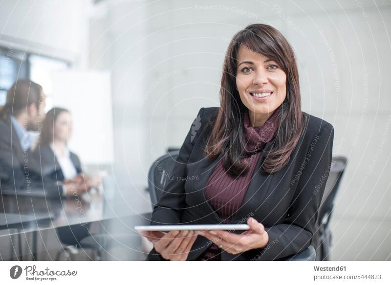 Porträt einer lächelnden Geschäftsfrau mit Tablette bei einer Besprechung im Konferenzraum Tablet Computer Tablet-PC Tablet PC iPad Tablet-Computer