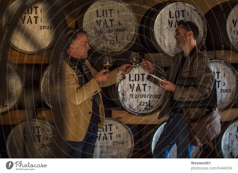 Menschen in der Destillerie beim Tanken von Whisky probieren Brennerei trinken Whiskey Verkostung Spirituosen Alkohol Alkoholische Getraenke