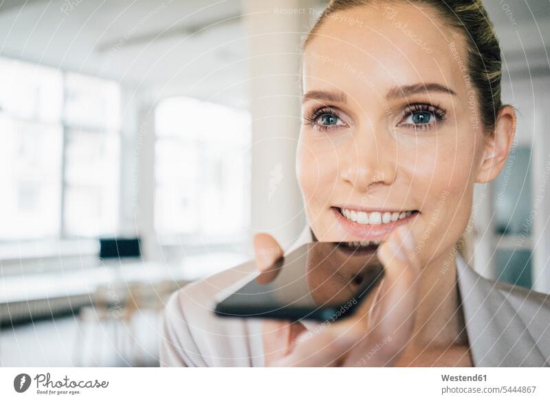 Porträt einer lächelnden Geschäftsfrau bei der Benutzung eines Mobiltelefons Geschäftsfrauen Businesswomen Businessfrauen Businesswoman telefonieren anrufen