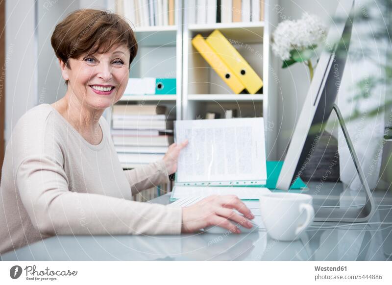 Ältere Frau arbeitet am Computer mit einer Tasse Kaffee weiblich Frauen arbeiten Arbeit lernen Seniorin älter Seniorinnen alt sitzen sitzend sitzt Erwachsener