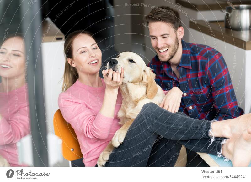 Glückliches junges Paar mit Hund zu Hause Hunde Pärchen Paare Partnerschaft glücklich glücklich sein glücklichsein Zuhause daheim Haustier Haustiere Tier
