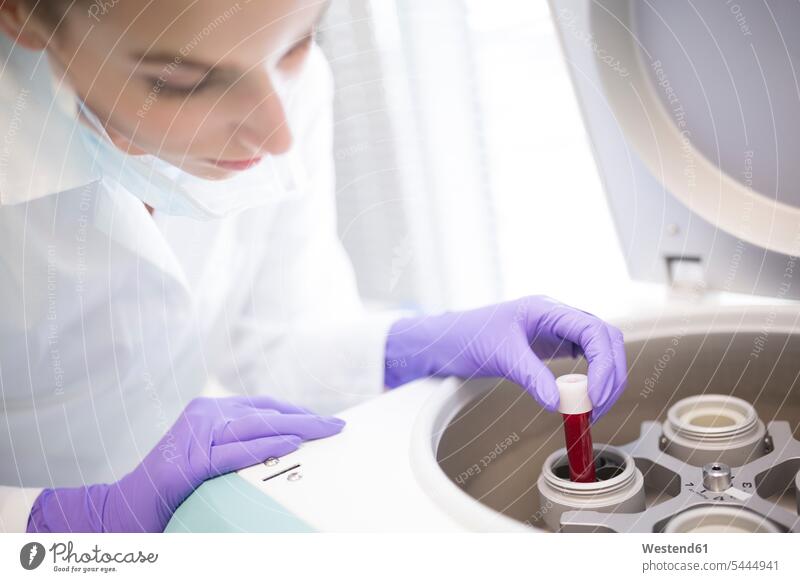 Wissenschaftler im Labor gibt Blutprobe in Zentrifuge Wissenschaftlerin Wissenschaftlerinnen Probe Muster untersuchen prüfen Blutproben Bluttest Bluttests