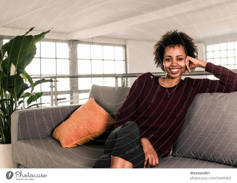 Porträt einer lächelnden jungen Frau auf einer Couch sitzend weiblich Frauen entspannt entspanntheit relaxt sitzt Erwachsener erwachsen Mensch Menschen Leute
