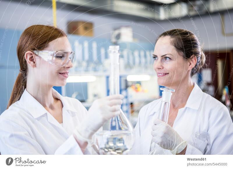 Zwei lächelnde Wissenschaftler arbeiten zusammen im Labor Labore Arbeit Wissenschaftlerin Wissenschaftlerinnen wissenschaftlich Wissenschaften Frau weiblich