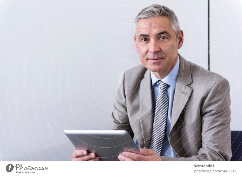 Portrait eines reifen Geschäftsmannes, der ein digitales Tablett benutzt Tablet Computer Tablet-PC Tablet PC iPad Tablet-Computer Kompetenz kompetent arbeiten