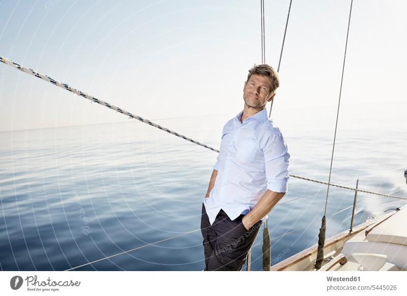 Porträt eines lächelnden reifen Mannes, der auf seinem Segelboot steht Portrait Porträts Portraits Segeln segelnd segelt Männer männlich Bootsport Erwachsener