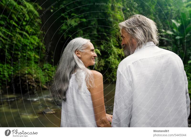 Hübsches älteres Paar lächelt sich im tropischen Dschungel an Natur Hände halten Haendchen halten Hand halten Haende halten Händchen halten Hand in Hand lächeln