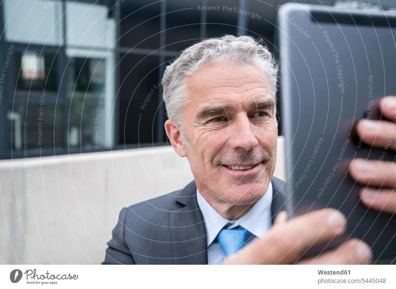 Reifer Geschäftsmann macht ein Smartphone-Selfie Videokonferenz Tablet Tablet Computer Tablet-PC Tablet PC iPad Tablet-Computer Manager fotografieren