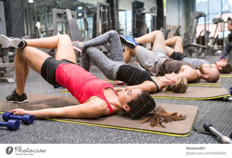 Gruppe von Sportlern, die im Fitnessstudio trainieren Fitnessclubs Fitnessstudios Turnhalle fit Gesundheit gesund aktiv Trainieren Übung Üben Übungen