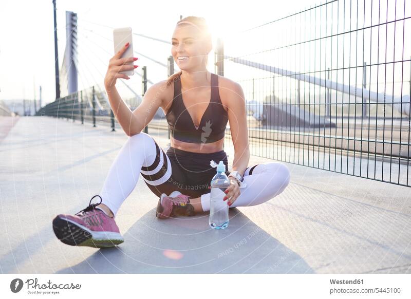 Fitte Frau macht Selfie nach Outdoor-Workout Selfies Urban städtisch Urbanität Urbanitaet Smartphone iPhone Smartphones fit weiblich Frauen Handy Mobiltelefon
