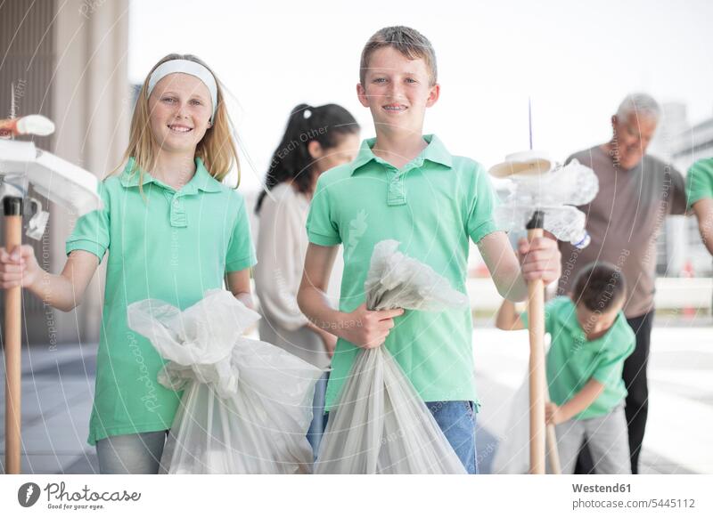Gruppe ehrenamtlich arbeitender Kinder, die mit Abfallstöcken Müll sammeln gesammelt Mülltüte Müllsack Schüler Abfälle Muell Abfaelle Müllpicker Tüte Tüten