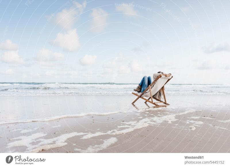 Frau sitzt auf Liegestuhl am Strand Beach Straende Strände Beaches sitzen sitzend weiblich Frauen Erwachsener erwachsen Mensch Menschen Leute People Personen