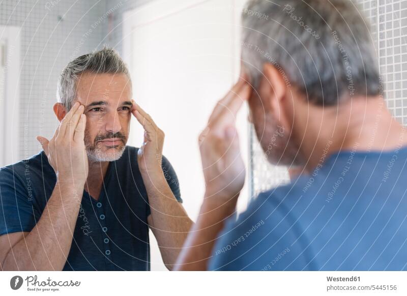 Reifer Mann schaut in den Badezimmerspiegel Männer männlich schauen schauend anschauen betrachten Spiegel Erwachsener erwachsen Mensch Menschen Leute People