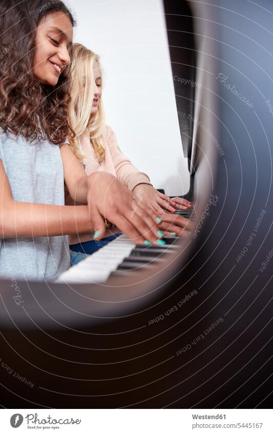 Zwei Mädchen spielen zusammen Klavier Piano Pianos Klaviere weiblich lächeln Musik Tasteninstrument Tasteninstrumente Musikinstrument Musikinstrumente