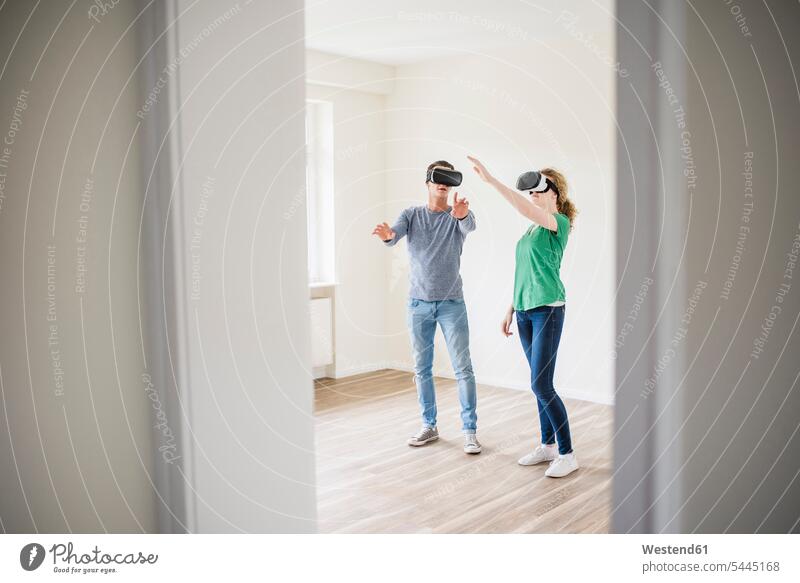 Junges Paar diskutiert in leerer Wohnung mit VR-Brille Virtual Reality Brille Virtual-Reality-Brille Virtual Reality-Brille VR Brille Pärchen Paare