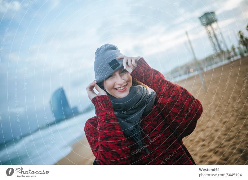 Porträt einer lächelnden jungen Frau am Strand im Winter Beach Straende Strände Beaches weiblich Frauen glücklich Glück glücklich sein glücklichsein Erwachsener