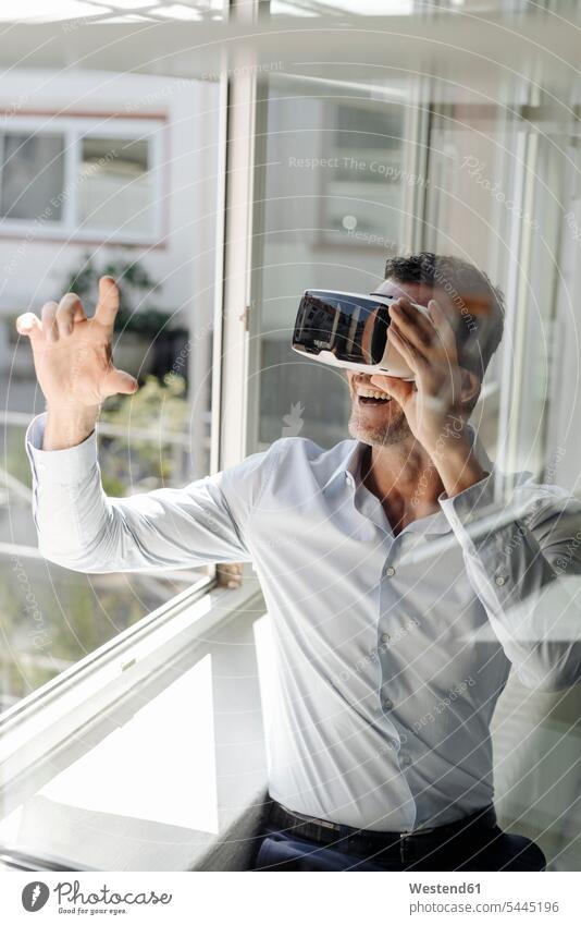 Geschäftsmann am Fenster mit VR-Brille Virtual Reality Virtuelle Realität Businessmann Businessmänner Geschäftsmänner Büro Office Büros Geschäftsleute