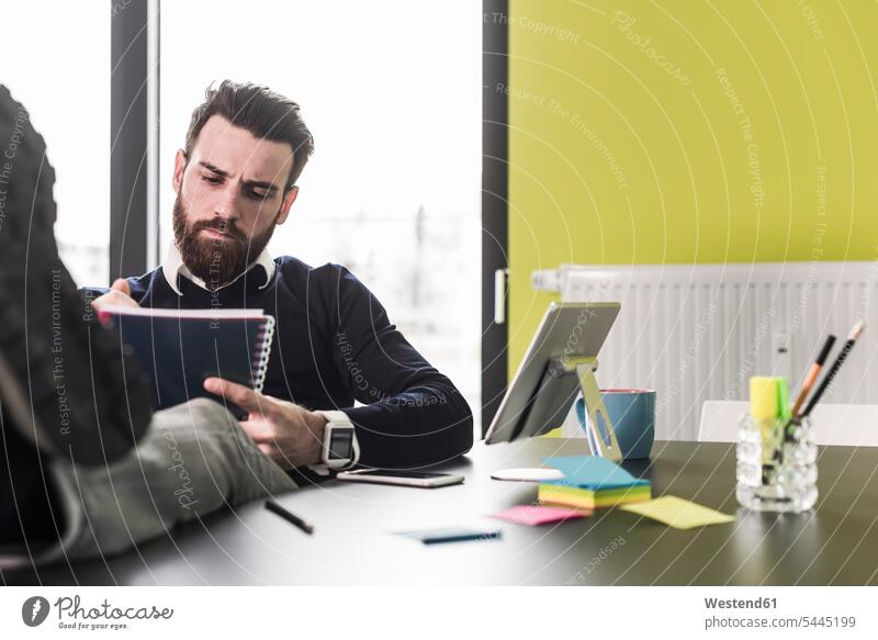 Geschäftsmann sitzt im Büro und liest Akten Unterlagen Weiterbildung lesen Bart Füße hochlegen Mappe Arbeitsplatz Bildung Mensch Businessmann Geschäftsleute