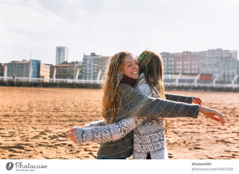 Zwei Freunde umarmen sich am Strand Freundinnen Beach Straende Strände Beaches Freundschaft Kameradschaft lächeln Heranwachsen Pubertaet Heranwachsende Pubertät