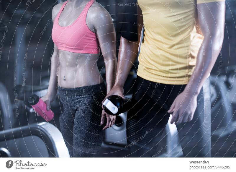 Mann und Frau im Fitnessstudio machen eine Pause Fitnessclubs Fitnessstudios Turnhalle trainieren fit Gesundheit gesund Sport Freizeit Muße Ausschnitt Teil
