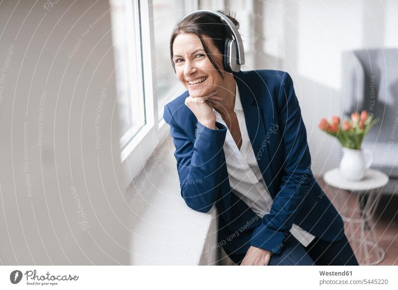 Porträt einer Frau, die mit Kopfhörern Musik hört Portrait Porträts Portraits Kopfhoerer Geschäftsfrau Geschäftsfrauen Businesswomen Businessfrauen