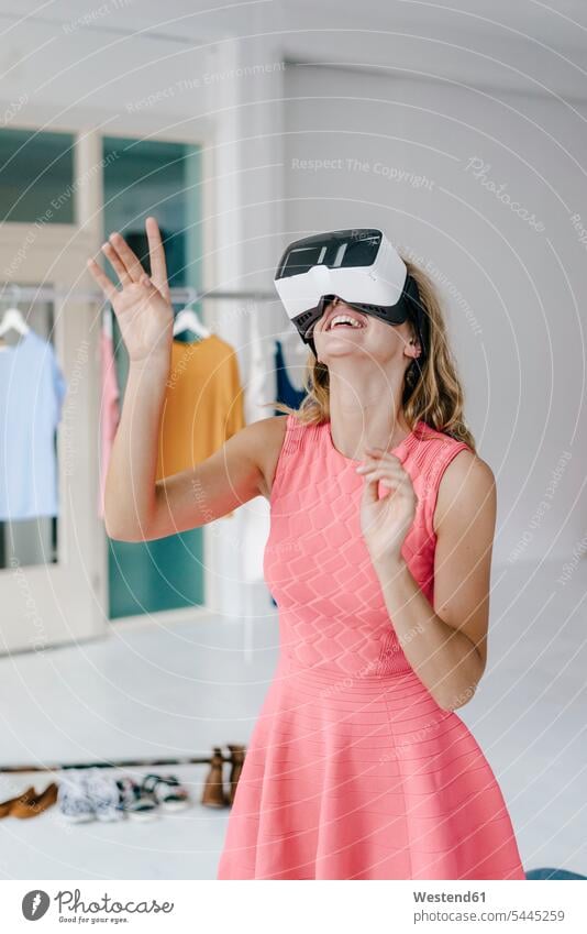 Glückliche junge Frau im Modeatelier mit VR-Brille glücklich glücklich sein glücklichsein Virtuelle Realität Virtuelle Realitaet Brillen Studio Atelier Studios