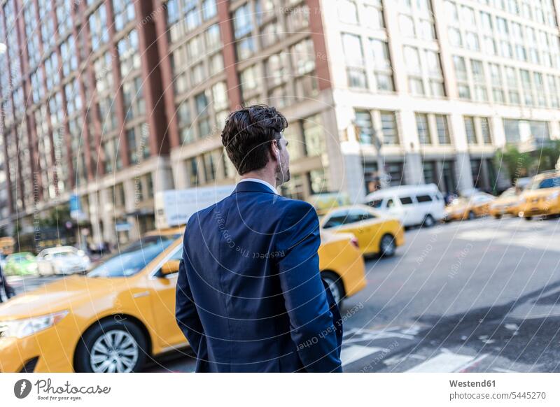 Geschäftsmann in den Straßen von Manhattan mit gelbem Taxi im Hintergrund attraktiv schoen gut aussehend schön Attraktivität gutaussehend hübsch telefonieren