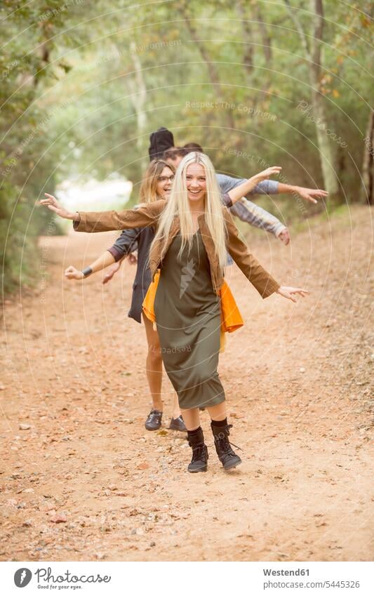 Vier glückliche Freunde amüsieren sich auf Waldwegen gehen gehend geht Forst Wälder Glück glücklich sein glücklichsein Freundschaft Kameradschaft Gemeinschaft