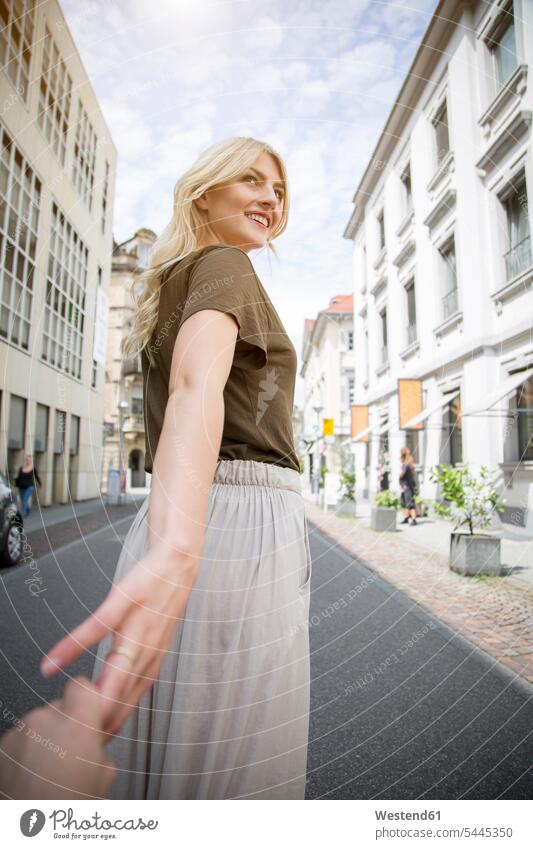 Lächelnde blonde Frau hält Hände auf der Straße weiblich Frauen Erwachsener erwachsen Mensch Menschen Leute People Personen blonde Haare blondes Haar