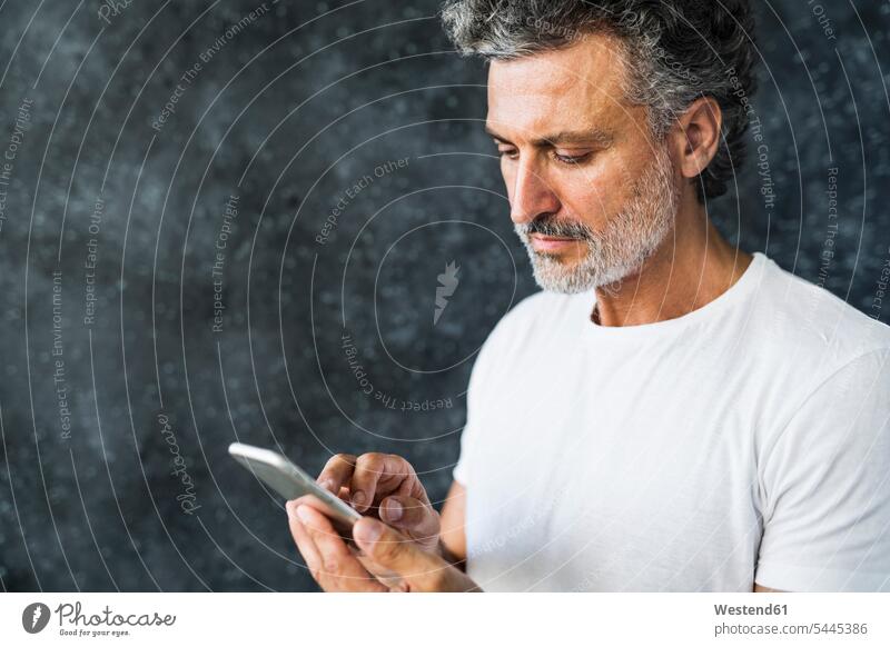 Erwachsener Mann benutzt Smartphone, sendet Textnachrichten reifer Mann reife Männer Nachricht Mitteilung Botschaft lesen Lektüre SMS iPhone Smartphones