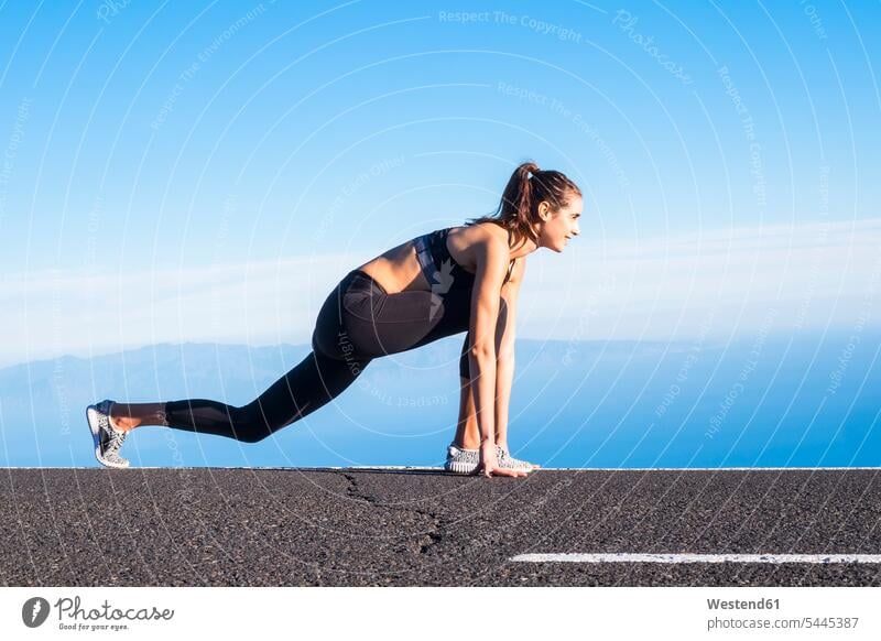 Junge Frau trainiert auf leerer Straße Sportlerin Sportlerinnen trainieren Strassen Straßen Joggerin Joggerinnen Verkehrswesen Transportwesen Joggen Jogging